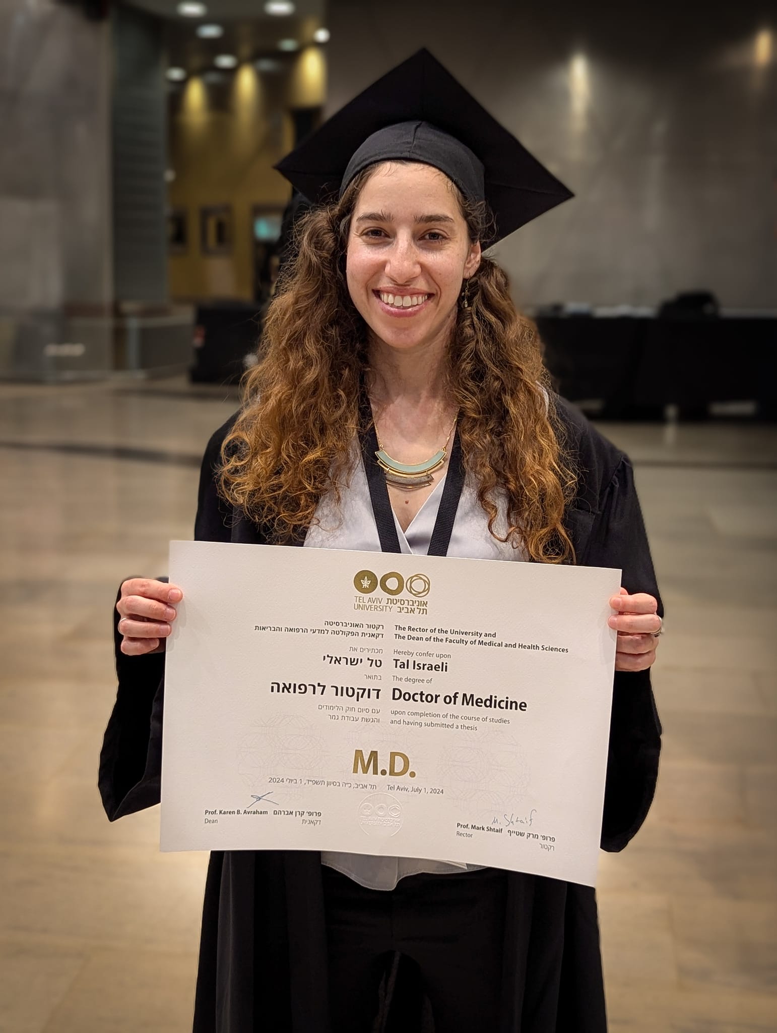 Graduation day holding M.D. diploma